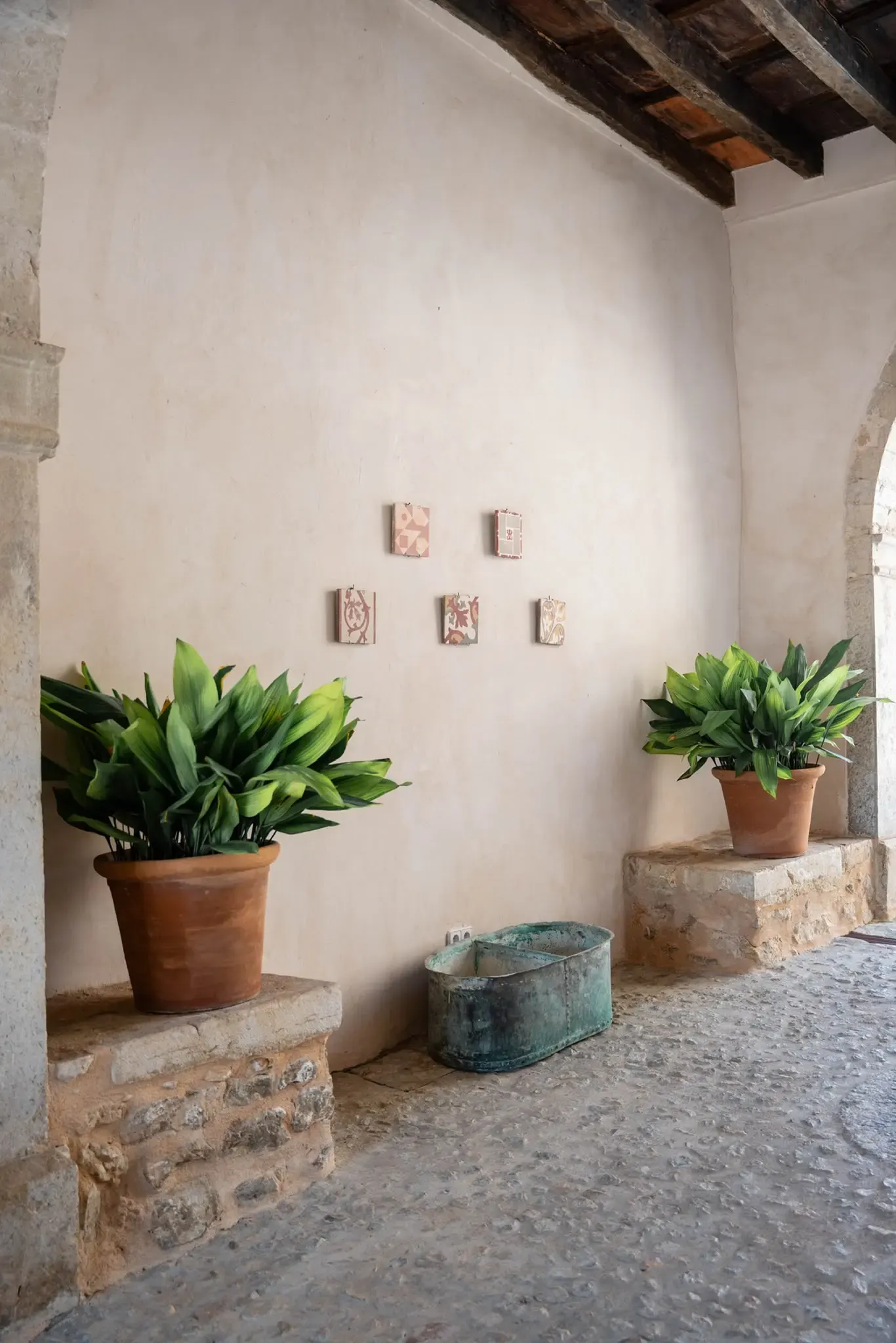 Shaded Mallorcan courtyard with terracotta pots and antique tiles